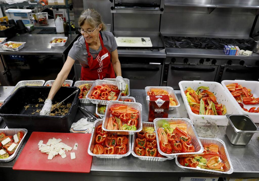 Deborah Cutler, a volunteer with Sonoma Family Meal, puts together stuffed bell peppers to be cooked in the kitchen of the Vintners Inn in Fulton, on Tuesday, October 24, 2017. (BETH SCHLANKER/ The Press Democrat)