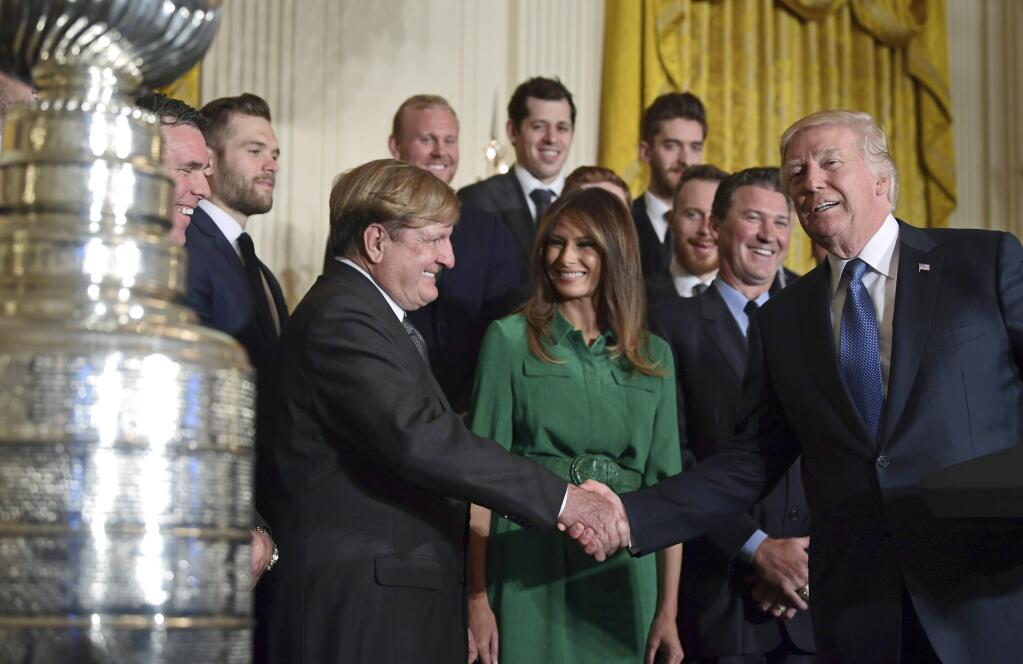 President Donald Trump, right, shakes hands with Pittsburgh Penguins owner Ronald Burkle, third from left, as first lady Melania Trump, center in green, watches, with Mario Lemieux during a ceremony to honor the 2017 NHL Stanley Cup Champion Pittsburgh Penguins, Tuesday, Oct. 10, 2017, in the East Room of the White House in Washington. (AP Photo/Susan Walsh)