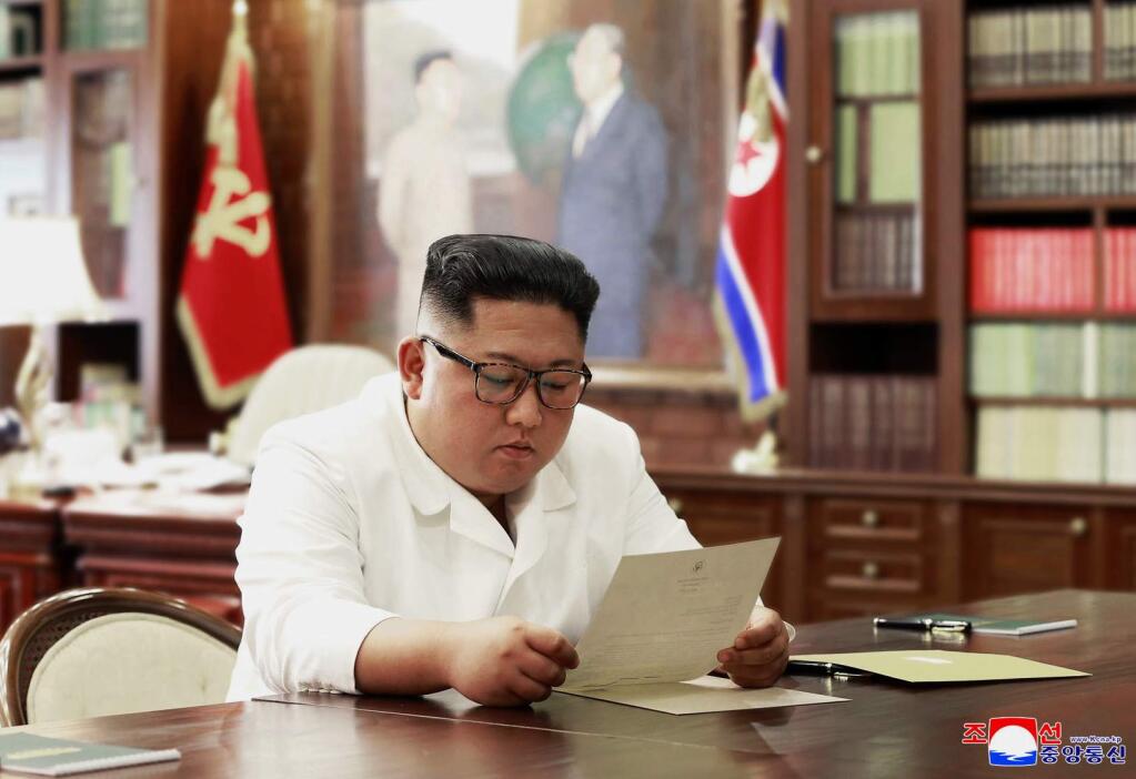 In this undated file photo provided on Sunday, June 23, 2019, by the North Korean government, North Korean leader Kim Jong Un reads a letter from U.S. President Donald Trump. South Korea's President Moon Jae-in on Tuesday, June 25, 2019, said North Korean and U.S. officials are holding 'behind-the-scenes talks' to set up a third summit between the countries' leaders. Korean language watermark on image as provided by source reads: 'KCNA' which is the abbreviation for Korean Central News Agency. (Korean Central News Agency/Korea News Service via AP, File)