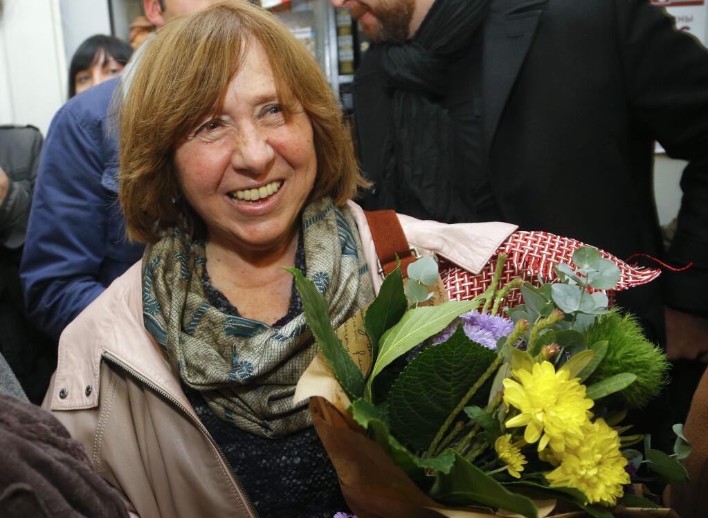 Belarusian journalist and writer Svetlana Alexievich who has been named the 2015 Nobel literature winner, holds flowers as she leaves a news conference in Minsk, Belarus, Thursday, Oct. 8, 2015. Belarusian writer Svetlana Alexievich won the Nobel Prize in literature Thursday, for works that the prize judges called 'a monument to suffering and courage.' (AP Photo/Sergei Grits)