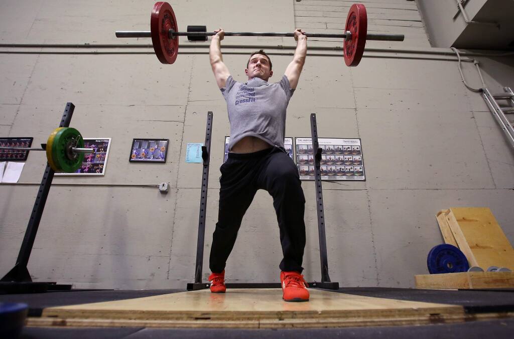 Devin Colwell performs a clean and jerk while working out at Santa Rosa Strength and Conditioning, in Santa Rosa on Tuesday, March 24, 2015. (Christopher Chung/ The Press Democrat)