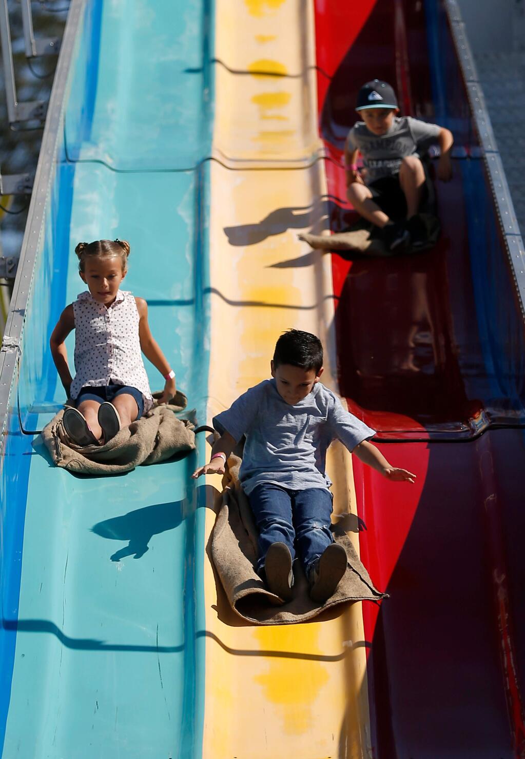 Brokke Rooney, 7, left, David Mendoza, 7, and Liam Rooney, 5, race down the Alpine Slide during the final weekend of the Sonoma County Fair in Santa Rosa, California on Saturday, August 6, 2016. (Alvin Jornada / The Press Democrat)