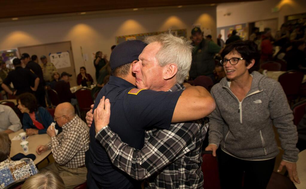 Mark Mollet, an Orange County fire captain, hugs Jeffrey Rothman of Santa Rosa, as Mollet and other firefighters are applauded as they arrive to enjoy a 'A Thousand Thanks Pancake Breakfast' presented by Boys Scouts Troop 32 at the Church of the Roses in Santa Rosa, Calif., on Saturday, October 21, 2017. (Photo by Darryl Bush / For The Press Democrat)