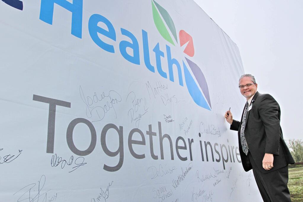 Frank R. Howard Memorial Hospital interim CEO Kevin Erich adds his name to a giant billboard to signify commitment to the new mission for the hospital. (HMH, March 22, 2017)