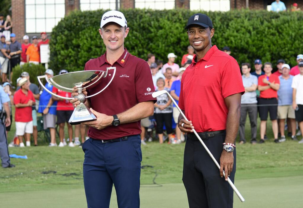 Justin Rose holds the FedEx Cup and Tiger Woods holds the Calamity Jane after winning the Tour Championship golf tournament Sunday, Sept. 23, 2018, in Atlanta. (AP Photo/John Amis)