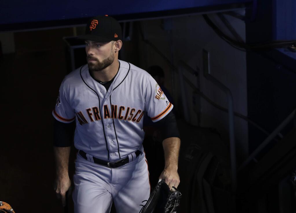 The San Francisco Giants' Mac Williamson walks to the dugout before a game against the Miami Marlins, Thursday, June 14, 2018, in Miami. (AP Photo/Lynne Sladky)