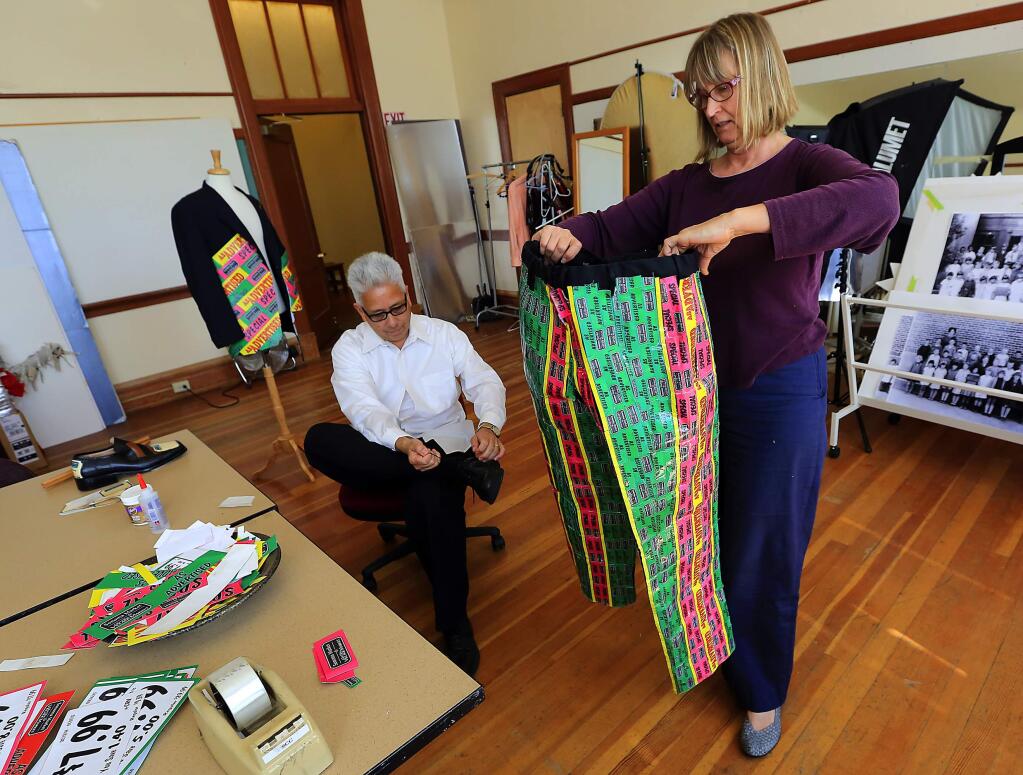 Al Minero, the general manager of Sonoma Market, tries on a suit made by designer Margaret Hatcher using weekly special stickers from the market. Minero will walk the catwalk in Sonoma's Trashion Fashion show. (Photo by John Burgess/The Press Democrat)
