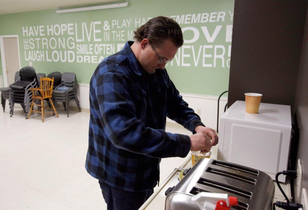 Resident Ricky Patton warms up a late meal in the dining room of the Catholic Charities Family Support Center in Santa Rosa, California, on Thursday, February 15, 2018. (Alvin Jornada / The Press Democrat)