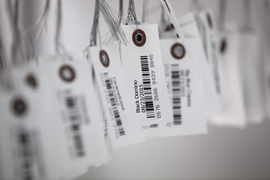 FILE - In this Sept. 24, 2015, file photo, tags with bar codes hang at a facility in Flandreau, S.D. George J. Laurer, whose invention of the Universal Product Code at IBM transformed retail and other industries around the world, died Thursday, Dec. 5, 2019, at his home in Wendell, N.C. He was 94. (AP Photo/Jay Pickthorn, File)