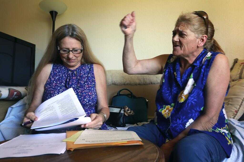 Paralegal Karen Hansell, left, prepares documents for Bonnie Mackey to join a suit against the landlord at Vintage at Bennett Valley apartments in Santa Rosa. (John Burgess/The Press Democrat)