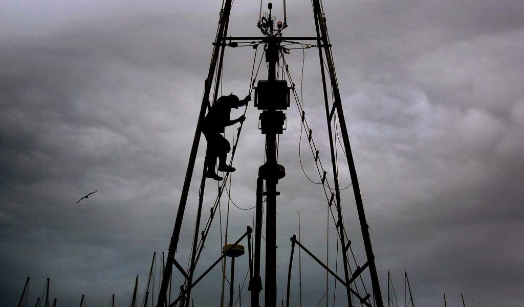 Deckhand Mike Duer on the Sandy B, captained by Stan Carpenter, descends rigging after adjusting an antenna, Thursday April 6, 2017 at Spud Point Marina in Bodega Bay. The fleet is taking another hit as salmon season looks to be delayed. (Kent Porter / The Press Democrat) 2017