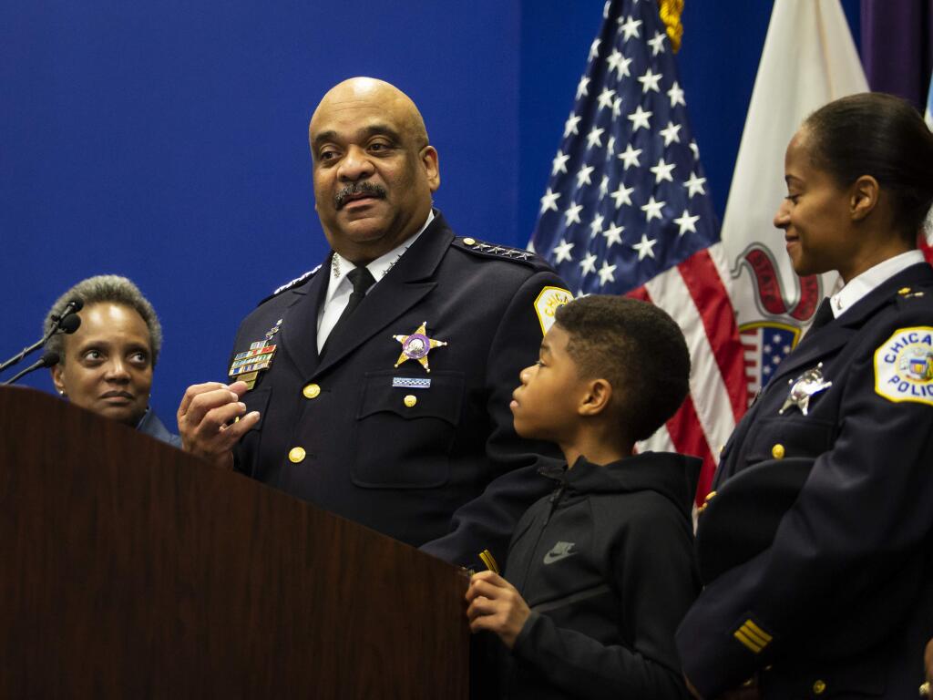 Chicago Police Department Supt. Eddie Johnson, with his 10-year-old son, his wife right, and and Mayor Lori Lightfoot, left, looking on, announces his retirement during a press conference at CPD headquarters, in Chicago, Thursday morning, Nov. 7, 2019. (Ashlee Rezin Garcia/Chicago Sun-Times via AP)