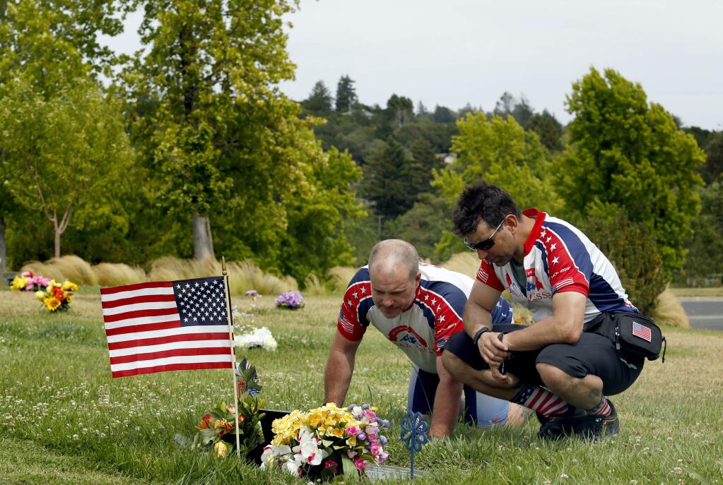 Kevin Mincio, right, and Kevin Collins, bicyclists for the Team Jesse Foundation, remember Army Sgt. Ryan Connolly at his grave at Santa Rosa Memorial Park in Santa Rosa, on Tuesday, June 9, 2015. (BETH SCHLANKER/ The Press Democrat)