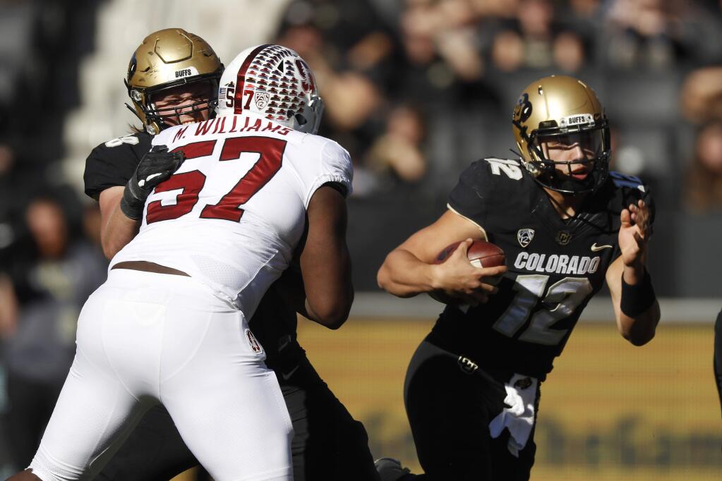 Stanford defensive tackle Michael Williams, front left, is stopped by Colorado offensive lineman Kary Kutsch, back left, as quarterback Steven Montez runs for a short gain in the first half of an NCAA college football game Saturday, Nov. 9, 2019, in Boulder, Colo. (AP Photo/David Zalubowski)