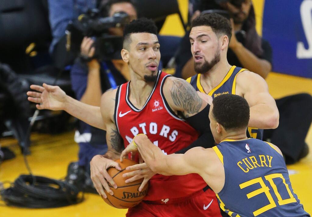 The Warriors' Klay Thompson and Stephen Curry double-team Raptors forward Danny Green during their game in Oakland on Wednesday, Dec. 12, 2018. (Christopher Chung / The Press Democrat)