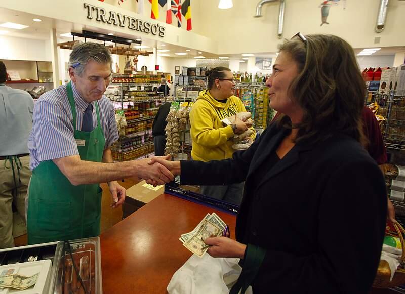 George Traverso receives a parting hand shake from Marie Cardenas of Healdsburg, Wednesday Nov. 23, 2011 during Traverso's last day of selling deli sandwiches. (KENT PORTER/ PD FILE)