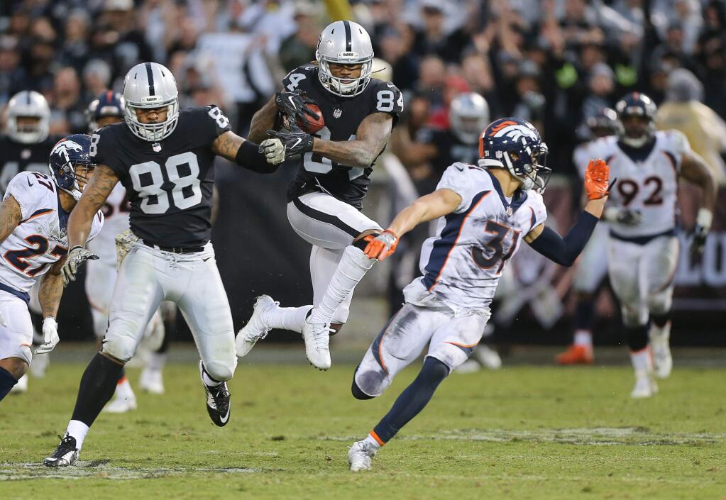 Oakland Raiders wide receiver Cordarrelle Patterson runs for a 54-yard gain after catching a deep pass from quarterback Derek Carr to clinch the game against the Denver Broncos in Oakland on Sunday, November 26, 2017. The Raiders defeated the Broncos 21-14.(Christopher Chung/ The Press Democrat)