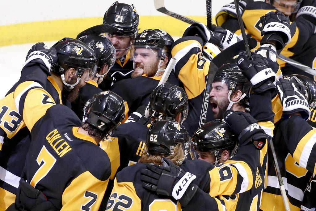 Pittsburgh Penguins celebrate as they gather around goalie Matt Murray after defeating the Tampa Bay Lightning 2-1 in Game 7 of the NHL hockey Stanley Cup Eastern Conference finals, Thursday, May 26, 2016, in Pittsburgh to advance to the Stanley Cup finals. (AP Photo/Gene J. Puskar)
