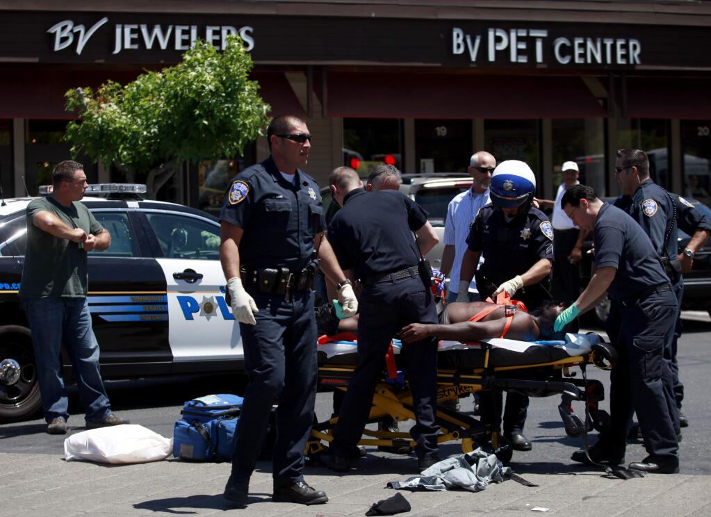 A suspect is taken by ambulance after a robbery at Bennett Valley Jewelers in Santa Rosa, Thursday, July 10, 2014. A second suspect was arrested in Oakland on Monday, Oct. 6. (Beth Schlanker / The Press Democrat)
