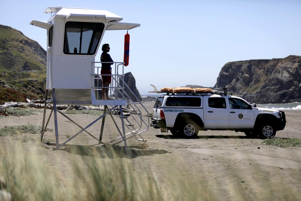 State Park lifeguard Christian Guiness looks out over the beach from the newly installed lifeguard tower at Goat Rock Beach- Sonoma Coast State Park in Jenner on Thursday, May 17, 2018. (Beth Schlanker/ The Press Democrat)