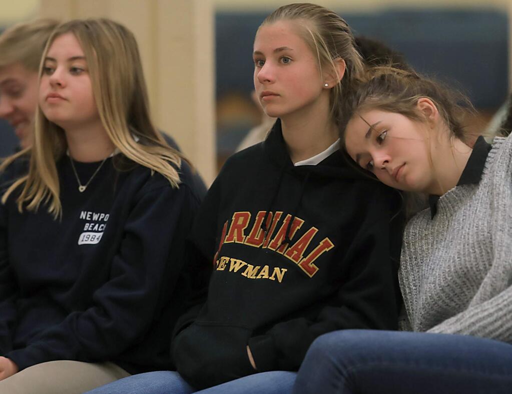 From left, Cardinal Newman freshman Emma Smits, Emily Schmidt and Jiana Zilke attend All Saints Day services, Friday Nov. 3, 2017 at Resurrection Church in Santa Rosa. The Cardinal Newman campus is shut down after being damaged by the Tubbs fire, and each grade grade is being taught at a different church in Cotati, Rohnert Park, Santa Rosa and Windsor. (Kent Porter / Press Democrat) 2017