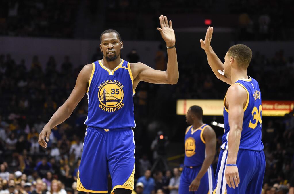 Golden State Warriors forward Kevin Durant, left, high-fives Stephen Curry (30) during the second half of an NBA preseason basketball game against the Los Angeles Lakers on Wednesday, Oct. 19, 2016, in San Diego. (AP Photo/Denis Poroy)