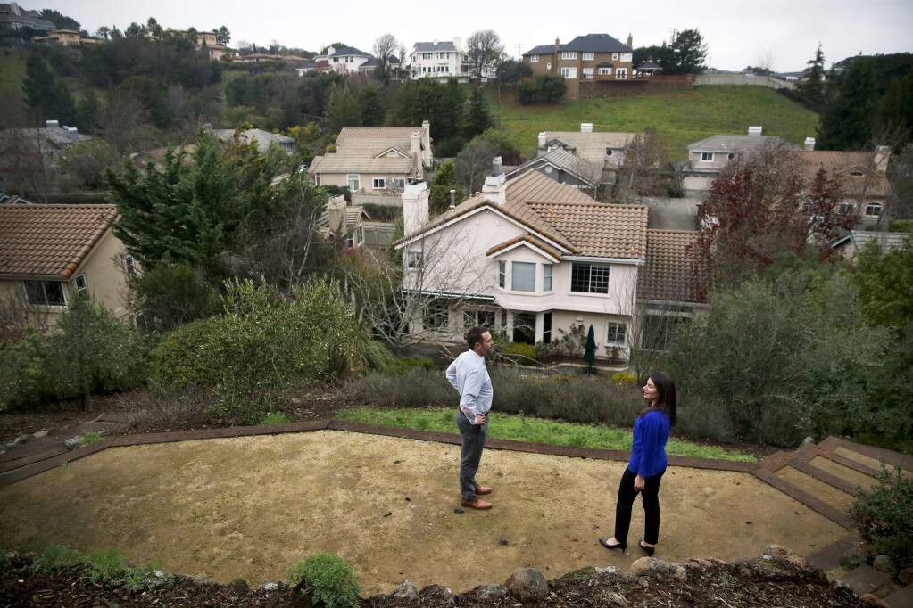 Real estate agent Jeremy King and Marisa Goldstein look at the backyard of the home for sale at 1217 B St. on Tuesday, January 16, 2018 in Petaluma, California . (BETH SCHLANKER/The Press Democrat)