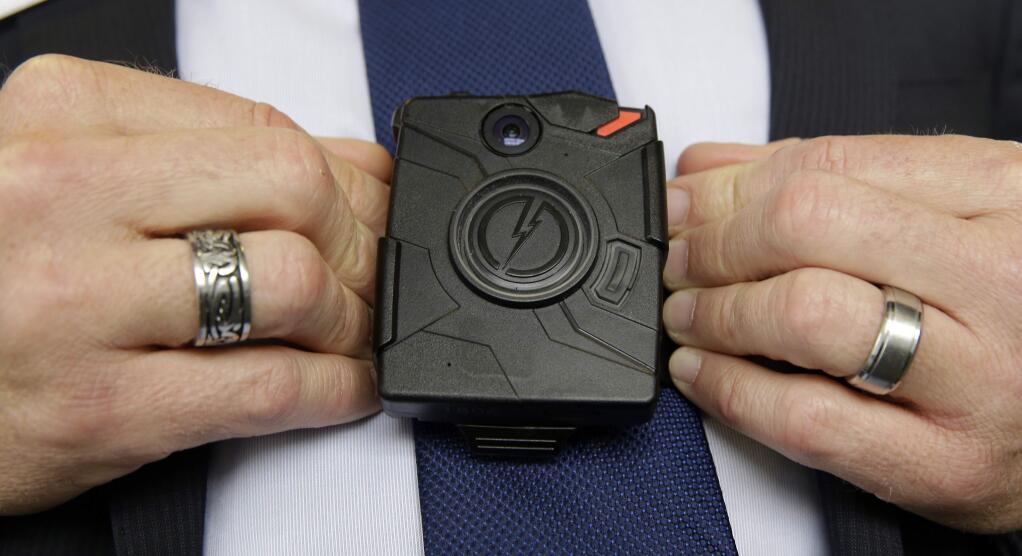 FILE - In this Feb. 19, 2015 file photo, Steve Tuttle, vice president of communications for Taser International, demonstrates one of the company's body cameras during a company-sponsored conference at the California Highway Patrol Headquarters in Sacramento, Calif. Sacramento police have issued a new directive on when officers can turn off body cameras. It comes after two officers muted their microphones minutes after fatally shooting Stephon Clark last month. The new memo, issued last week, was discussed at a Monday, April 9, 2018, police commission meeting. (AP Photo/Rich Pedroncelli,File)