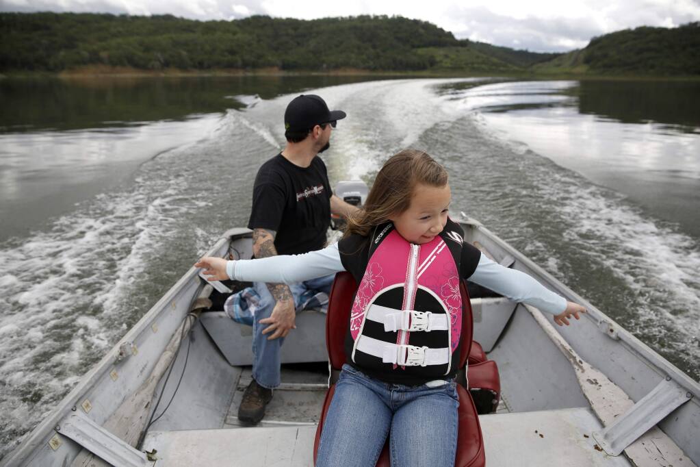 Emma Bushby, 8, outstretches her arms in the wind as her dad, Ryan, drives their boat at Lake Mendocino on Sunday, March 22, 2015 in Ukiah, California . (BETH SCHLANKER/ The Press Democrat)