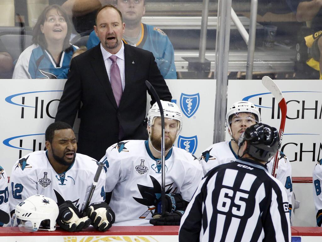 San Jose Sharks coach Peter DeBoer speaks to linesman Pierre Racicot (65) during the first period against the Pittsburgh Penguins in Game 2 of the NHL hockey Stanley Cup Finals on Wednesday, June 1, 2016, in Pittsburgh. (AP Photo/Gene J. Puskar)