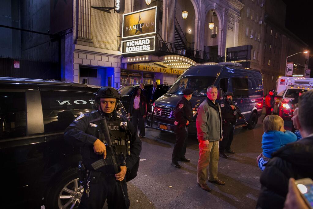 Heavily armed police stand guard as a motorcade carrying Vice President-elect Mike Pence, center, leaves the Richard Rodgers Theatre after a performance of 'Hamilton,' in New York, Friday, Nov. 18, 2016. (AP Photo/Andres Kudacki)