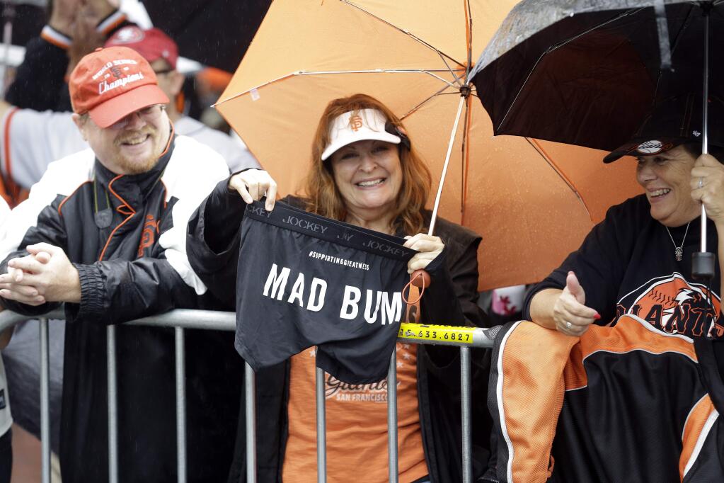 San Francisco Giants baseball fan Cheryl Shawl holds a pair of 'Mad Bum' underwear as she waits in the rain for the start of the victory parade for the 2014 World Series Champions San Francisco Giants on Friday, Oct. 31, 2014 in San Francisco. (AP Photo/Jeff Chiu)