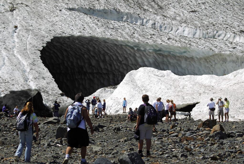 In this July 2010 photo, visitors examine the Big Four Ice Caves in the Mt. Baker-Snoqualmie National Forest near Granite Falls, Wash. The Snohomish County sheriff's office says rescuers responded to a report of a partial collapse of the ice caves Monday, July 6, 2015. (Mark Mulligan/The Herald via AP)
