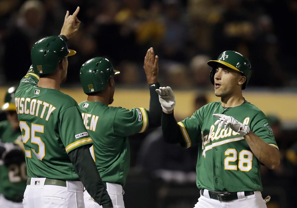 The Oakland Athletics' Matt Olson, right, celebrates with Stephen Piscotty and Marcus Semien, center, after hitting a three-run home run off the Seattle Mariners' Wade LeBlanc during the fourth inning, Friday, May 24, 2019, in Oakland, Calif. (AP Photo/Ben Margot)