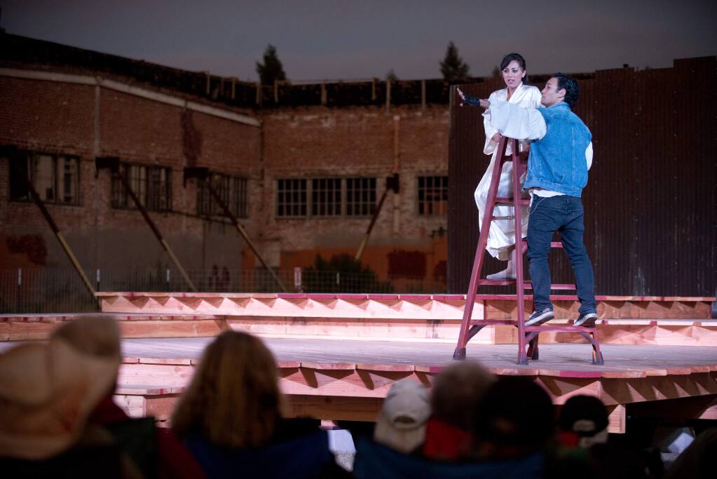 Carmen Mitchell, left, in the role of Juliet, and Kot Takahashi, playing Romeo perform the famed balcony scene during a production of Romeo and Juliet by Shakespeare in the Cannery at the site of the former California Packing Company's Plant No. 5 on 3rd Street in Santa Rosa, California, on July 18, 2014. (Alvin Jornada / For The Press Democrat)