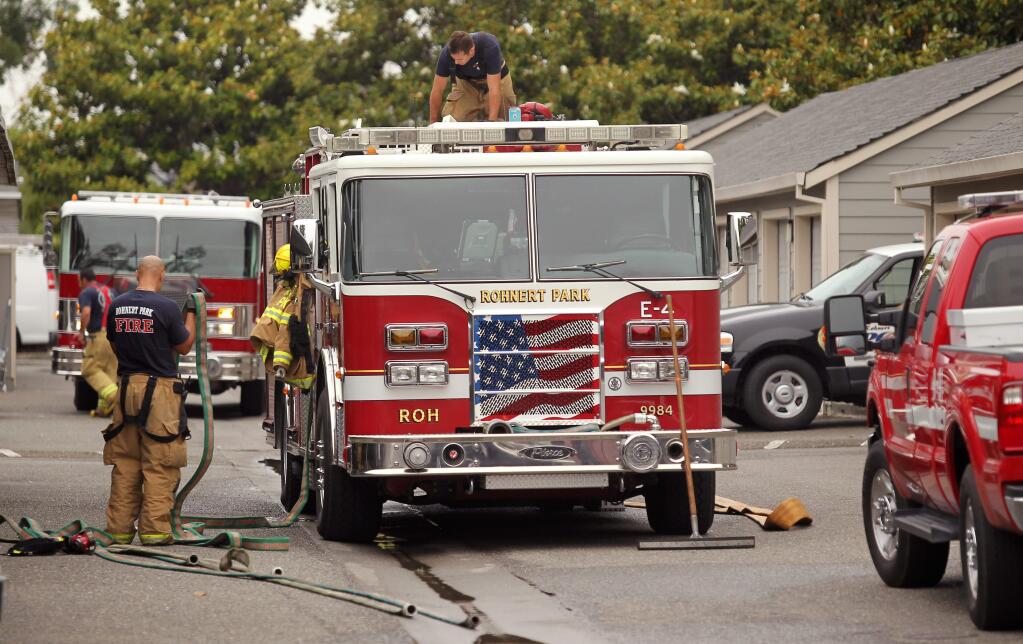 Rohnert Park firefighters clean up their equipment after a dryer fire in an apartment on Camino Colegio on July, 9, 2012. (JOHN BURGESS/Press Democrat)