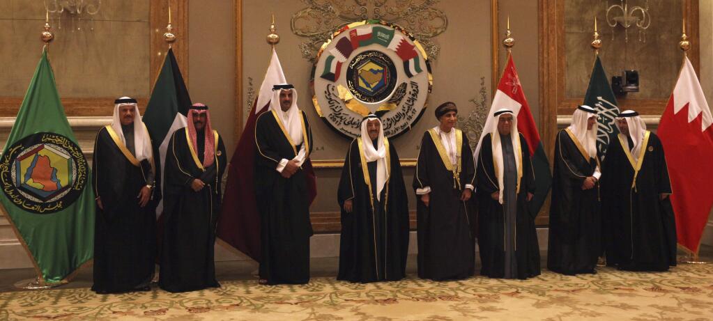 Officials gather for a group photograph, with Qatar's emir, Sheikh Tamim bin Hamad Al Thani, third left, and Kuwait's emir, Sheikh Sabah Al Ahmad Al Sabah, center, at the Gulf Cooperation Council summit in Kuwait City, Tuesday, Dec. 5, 2017. Kuwait hosted a meeting Tuesday of the Gulf Cooperation Council that saw Qatar's ruling emir attend, but other rulers stayed away amid the ongoing boycott targeting Doha. (AP Photo/Jon Gambrell)