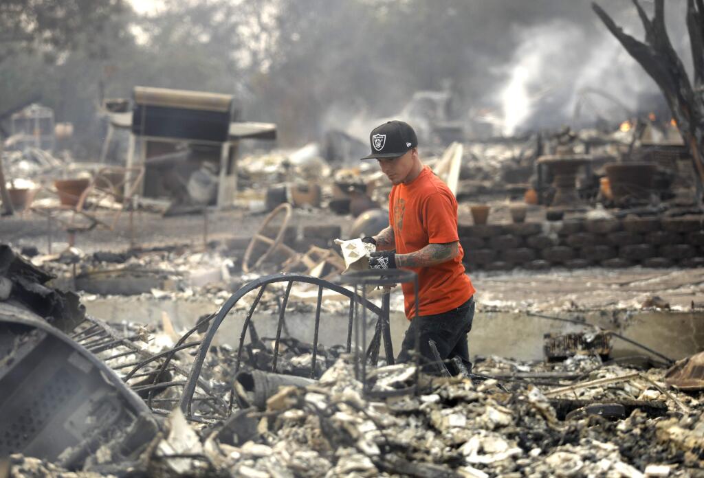 Chris Cortese looks to salvage something from his parents home after it was destroyed by fire in Santa Rosa, on Monday, October 9, 2017. (BETH SCHLANKER/ The Press Democrat)