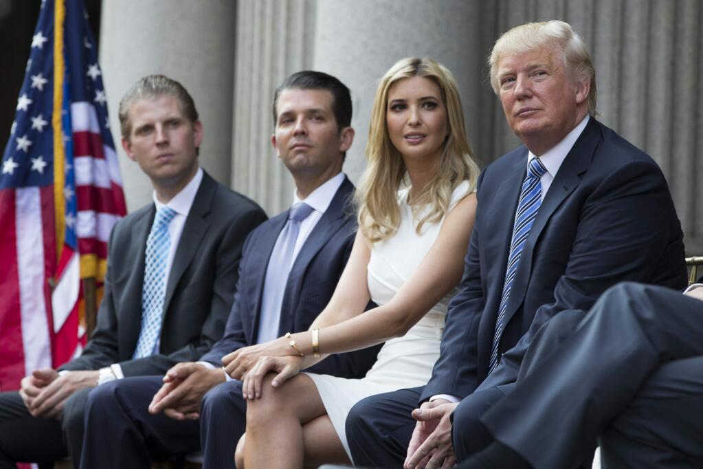 Donald Trump, right, sits with, from left, Eric Trump, Donald Trump Jr., and Ivanka Trump during a ground breaking ceremony for the Trump International Hotel on the site of the Old Post Office, on Wednesday, July 23, 2014, in Washington. (AP Photo)