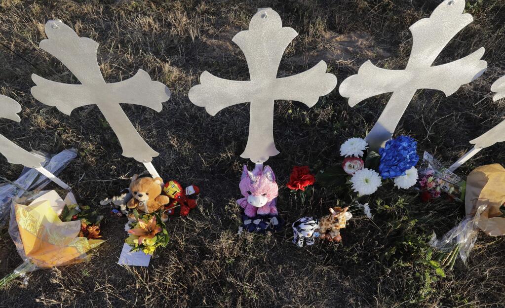 Flowers and stuffed animals rest at the base of crosses at a makeshift memorial for the First Baptist Church victims Tuesday, Nov. 7, 2017, in Sutherland Springs, Texas. A man opened fire inside the church in the small South Texas community on Sunday, killing more than two dozen and injuring others. (AP Photo/David J. Phillip)