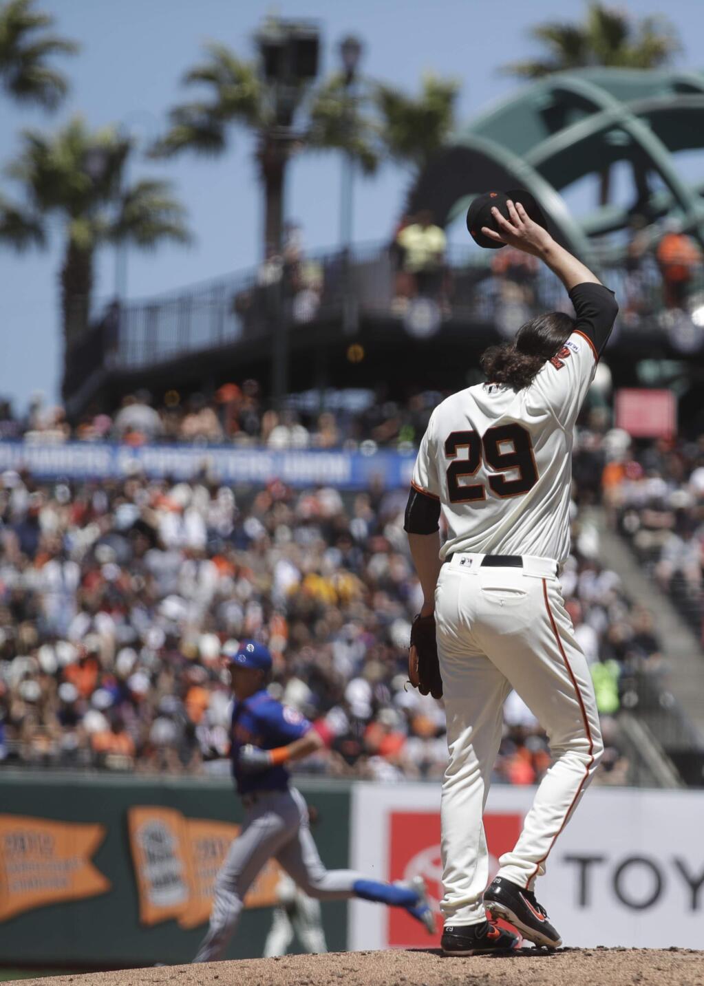 San Francisco Giants pitcher Jeff Samardzija wipes his face as the New York Mets' Jeff McNeil, left, runs the bases after hitting a two-run home run in the fifth inning Saturday, July 20, 2019, in San Francisco. (AP Photo/Ben Margot)
