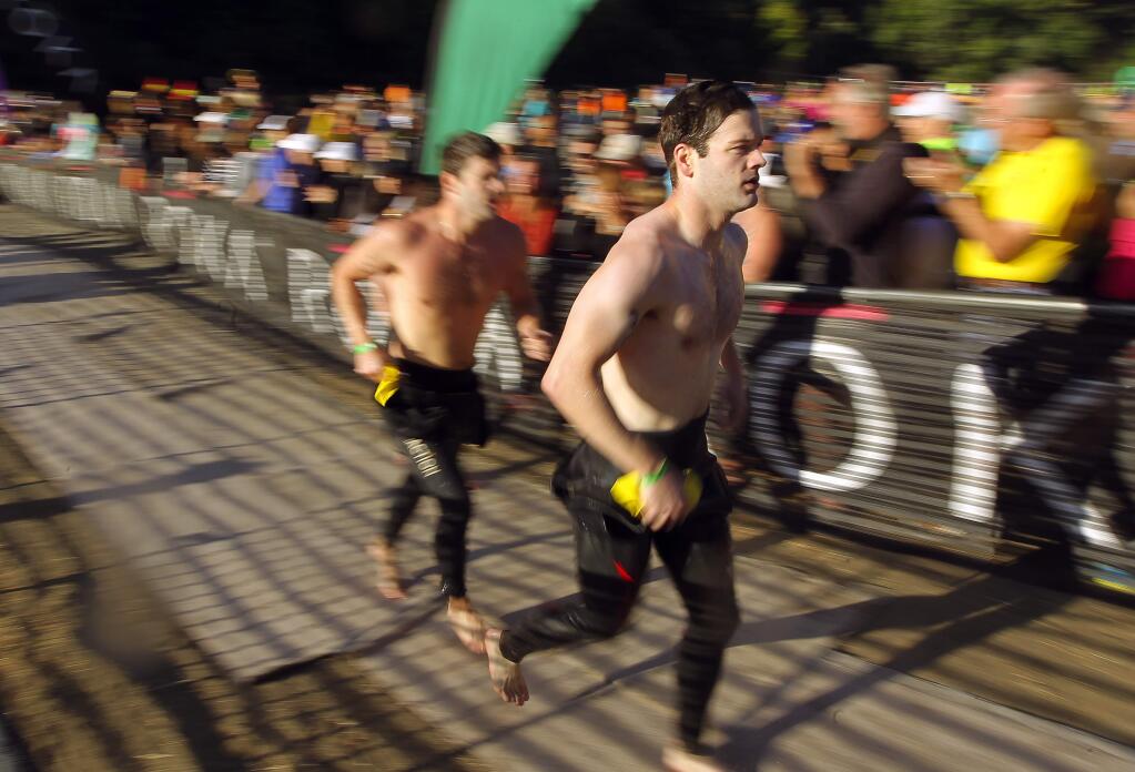 Vineman triathletes run for their bicycles after completing the swim in the Russian River at Johnson's Beach in Guerneville.