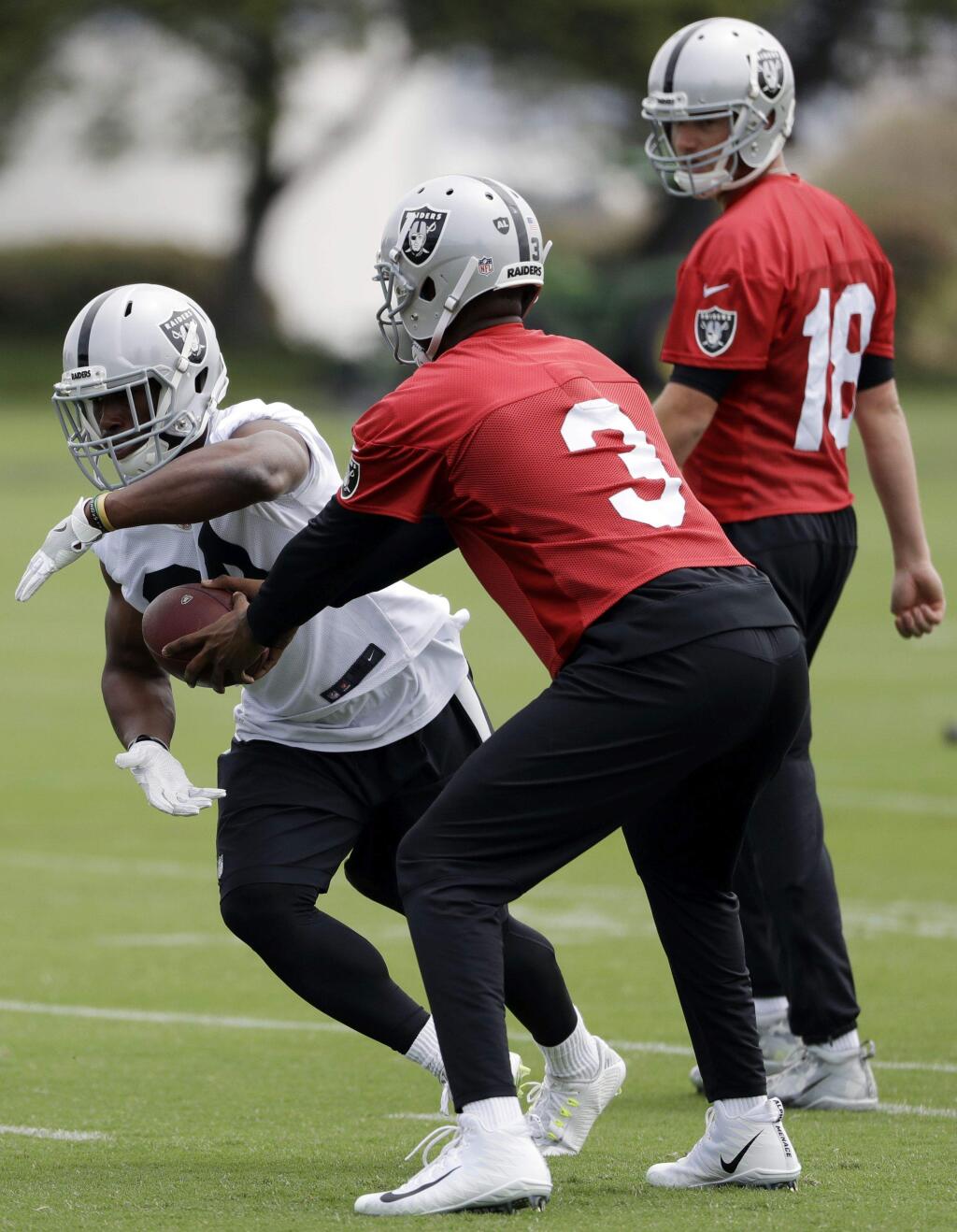 Oakland Raiders running back Elijah Hood, left, takes a handoff from quarterback EJ Manuel during the team's practice Tuesday, May 30, 2017, in Alameda. (AP Photo/Marcio Jose Sanchez)