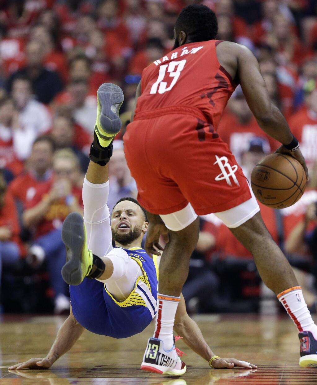 Golden State Warriors guard Stephen Curry, left, falls down after being bumped by Houston Rockets guard James Harden during the first half of Game 4 of a second-round NBA basketball playoff series, Monday, May 6, 2019, in Houston. (AP Photo/Eric Christian Smith)