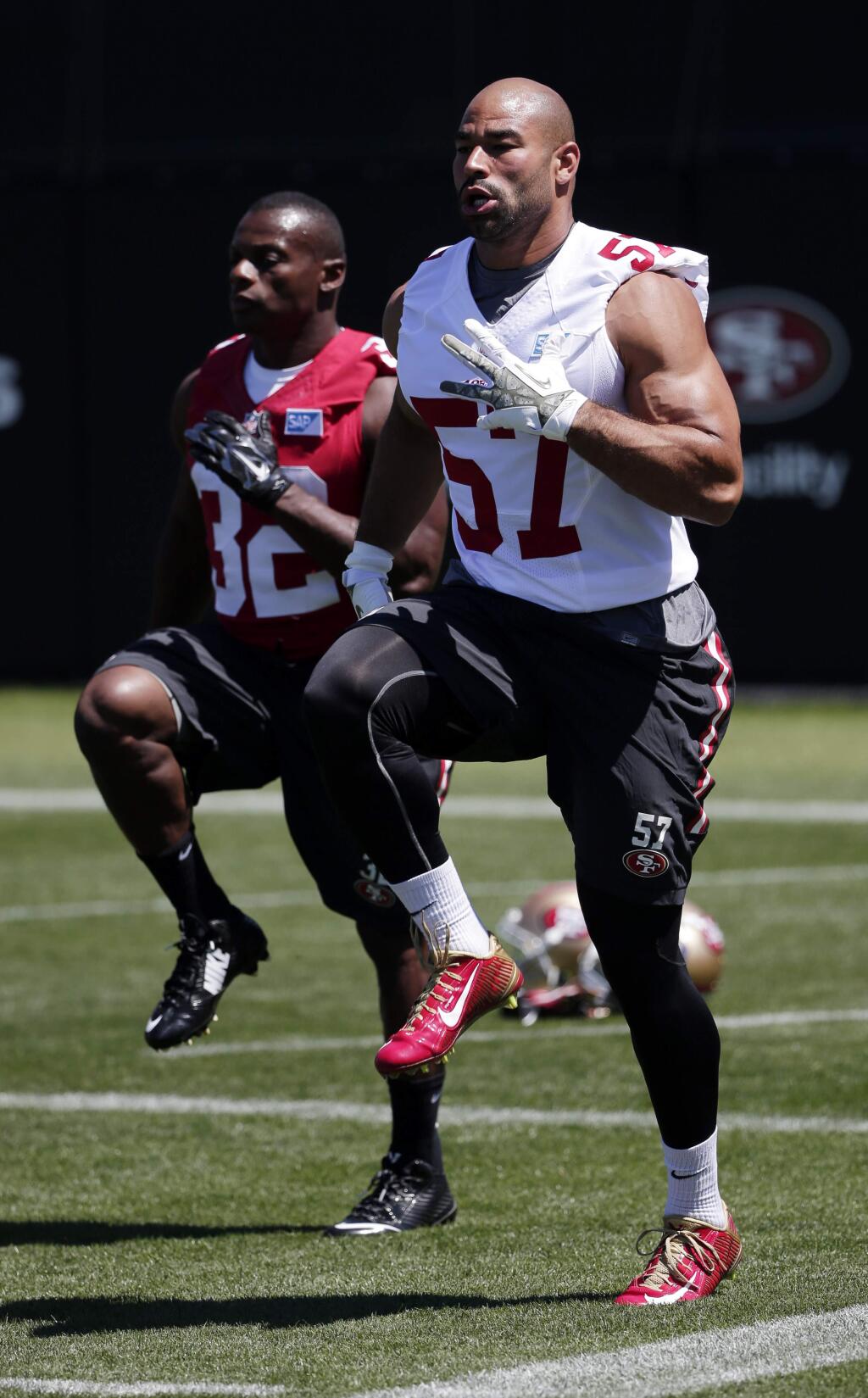 San Francisco 49ers linebacker Michael Wihoite (57) warms up next to teammate Kendall Hunter (32) during an NFL football training camp on Friday, July 25, 2014, in Santa Clara, Calif. (AP Photo)
