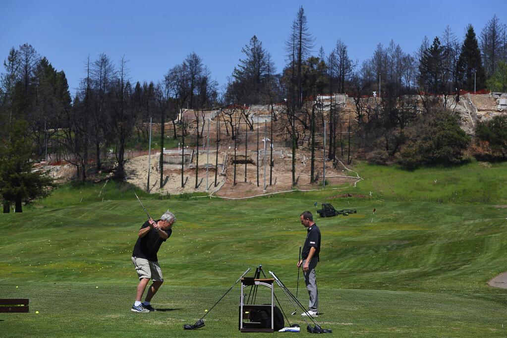 Greg Kappes, left, tries out new golf clubs with assistant golf professional Erick Andres on the Fountaingrove Club driving range, in Santa Rosa on Wednesday, April 25, 2018. Kappes lost his Bellagio Court home in the October wildfires, and is replacing his burned clubs. (Christopher Chung/ The Press Democrat)