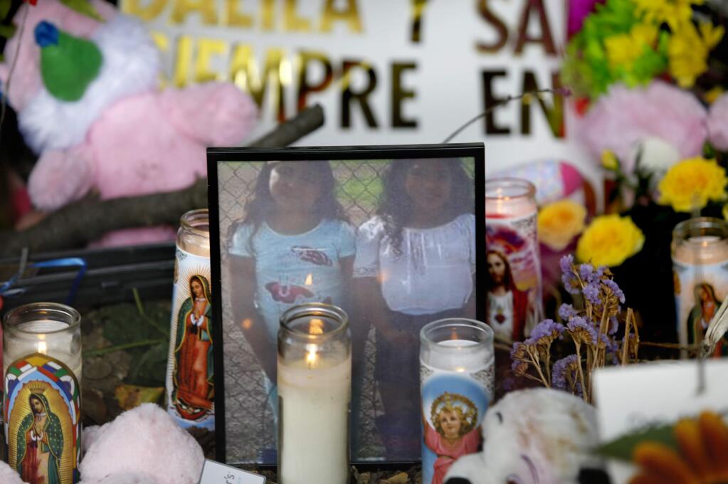 A photo of sisters Sayra, 7, and Delilah Gonzalez, 9, at a makeshift memorial for them along Petaluma Blvd North near the spot where their car went down a wooded embankment and into the Petaluma River on Wednesday. Photo taken on Thursday, September 1, 2016 in Petaluma, California . (BETH SCHLANKER/ The Press Democrat)
