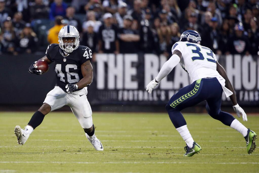 Oakland Raiders running back Jalen Richard (46) tries to get around Seattle Seahawks strong safety Kelcie McCray (33) during the first half of a preseason NFL football game Thursday, Sept. 1, 2016, in Oakland, Calif. (AP Photo/Tony Avelar)