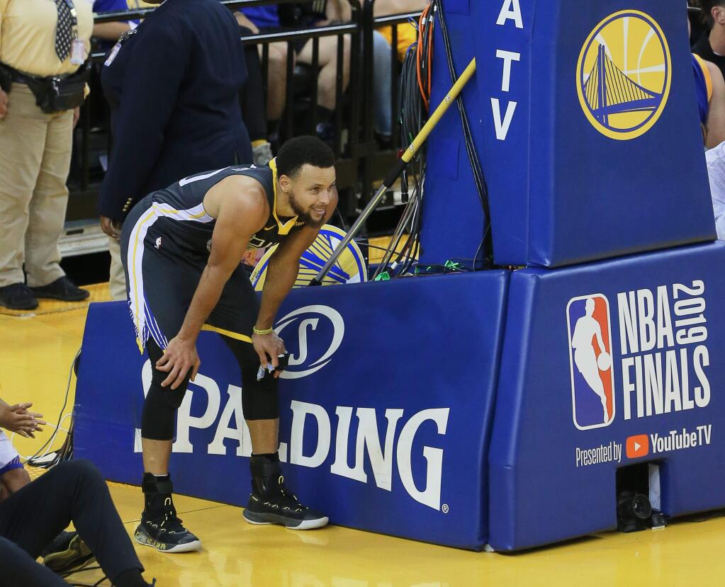 Golden State Warriors guard Stephen Curry takes a moment on the sideline after being fouled by the Toronto Raptors during Game 4 of the NBA Finals in Oakland on Friday, June 7, 2019. (Christopher Chung/ The Press Democrat)