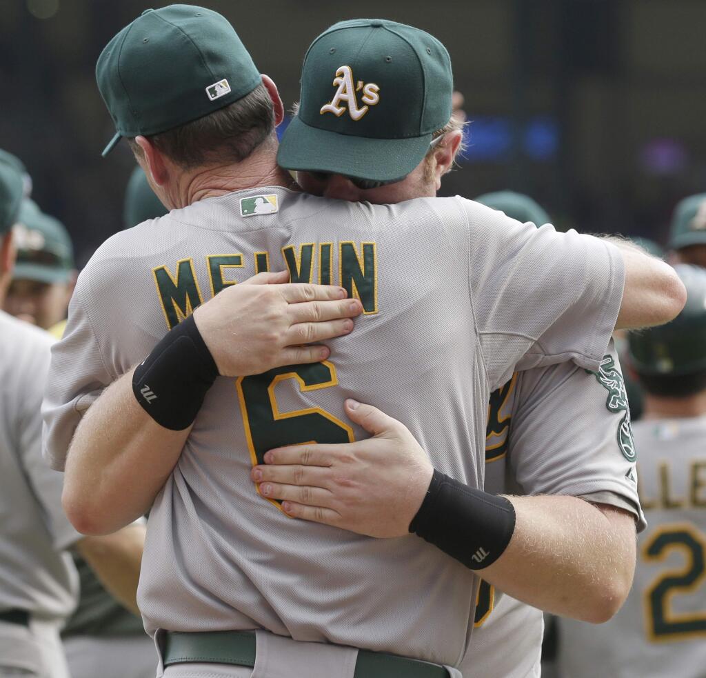 Oakland Athletics manager Bob Melvin (6) is hugged by designated hitter Adam Dunn after a baseball game against the Texas Rangers in Arlington, Texas, Sunday, Sept. 28, 2014. (AP Photo/LM Otero)